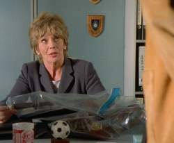 Grisham at her desk with the Liverpool FC mug and the football on it.