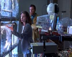 Holly adjusts the photon rods in the machine as Slade looks on